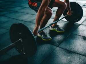 Homem fazendo levantamento terra, um dos melhores exercícios que trabalha a maioria dos músculos do corpo